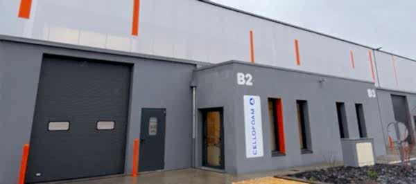 graues Firmengebäude mit Rolltor und Fenster