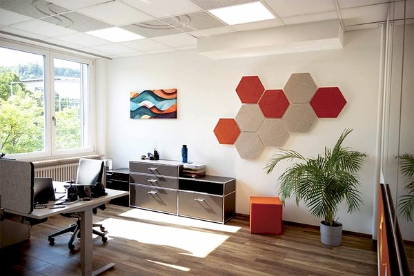 kleines Büro mit sechseckigen Schallabsorbern und einem Akustikbild an der Wand