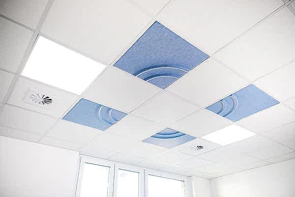 blaue Deckeneinleger mit Wellenmuster in weißer Rasterdecke