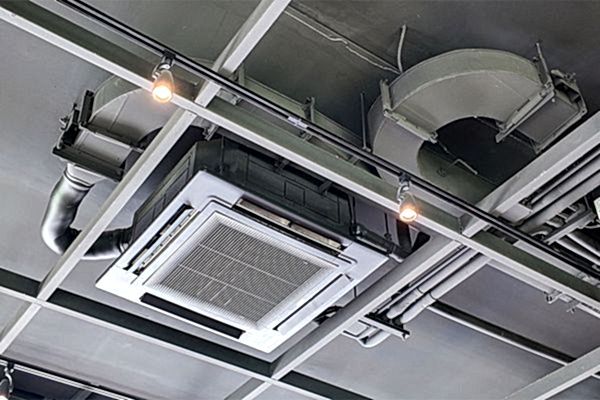 graue Zimmerdecke mit Lüftungskanälen und einem großen Auslass