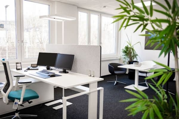 Schreibtisch mit grauer Tischtrennwand in einem Büro