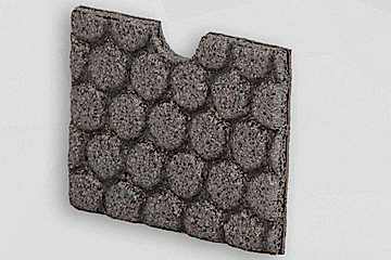 Graue Schaumstoffplatte mit Noppenmuster stehend vor grauem Hintergrund