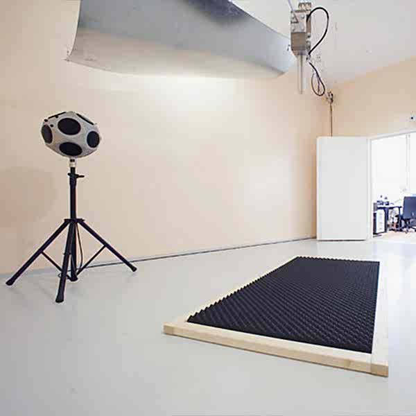 Ein kahler Raum mit einer Lautsprecherkugel und Schallschutzmaterial auf dem Boden