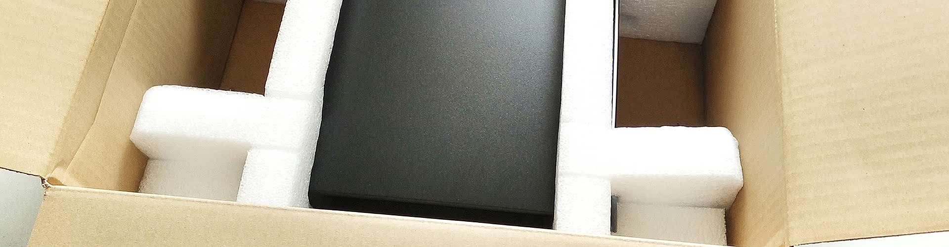 schwarzes Gerät von weißem Verpackungsschaum in einem Karton gesichert